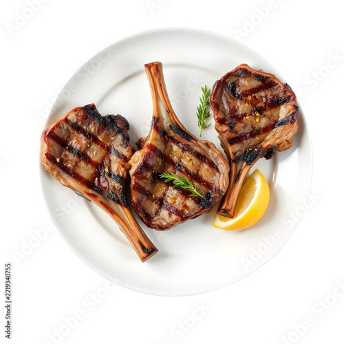 Grilled Greek lamb chops with lemon, oregano, and charred edges isolated on white background.
