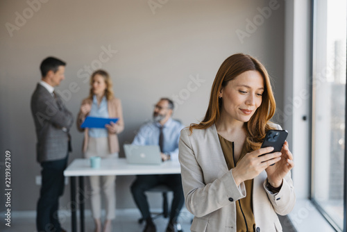 Businesswoman using smartphone in modern corporate office
