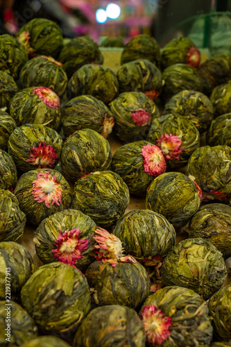 Round green buds, each crowned with pinkish-red petals