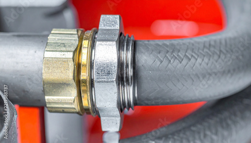 Coupling Connection: A close-up shot reveals a secure connection between two industrial hoses, featuring a brass and silver metal coupling, highlighting engineering precision and fluid transfer.