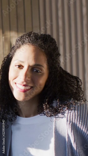 Vertical video: Light causing Black woman tilting head in cardigan, friend coming laughing to greet