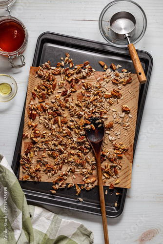 A candied pecan mixture on a cookie sheet cooling.
