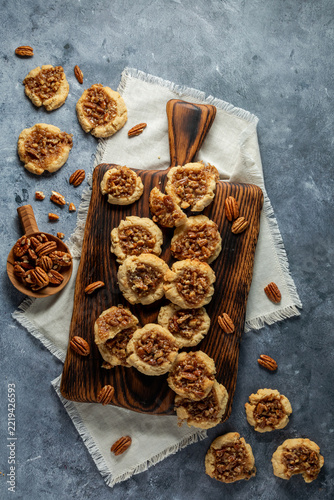 An arrangement of Pecan Pie Cookies on a wooden cutting board. 