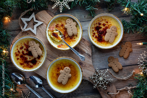 Above view of servings of Creme Brulee topped with gingerbread men biscuits.