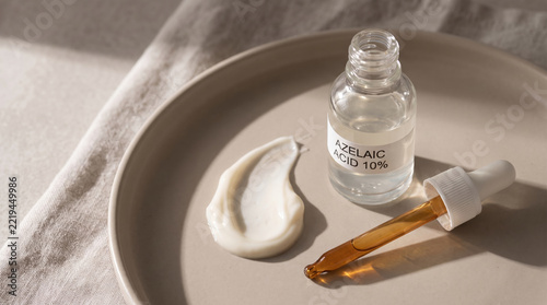 Azelaic acid skincare serum with cream and dropper on ceramic tray in warm sunlight
