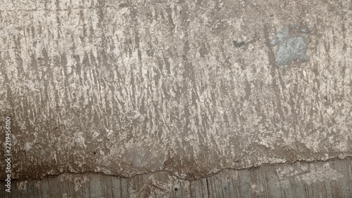 Close-up of an aged concrete surface with rough gray brown texture, weathered marks, scratches, and natural cracks. Ideal for grunge backgrounds, industrial designs, architecture, and 