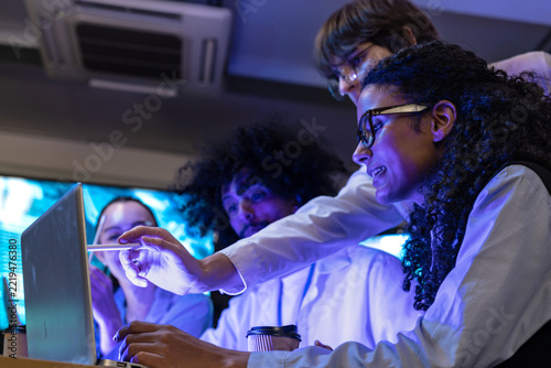 Fotografie Cinematic shot of a diverse, multiethnic software team react together to the scr