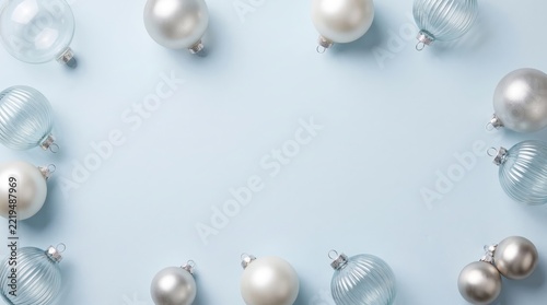 Silver and white christmas baubles on light surface isolated on white background