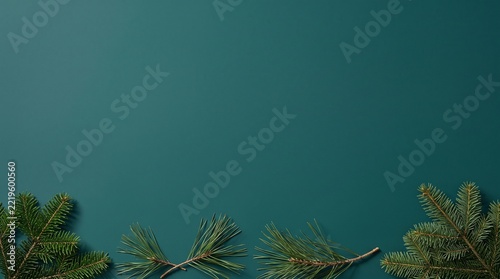 Fresh evergreen pine branches arranged along the bottom of a dark teal
