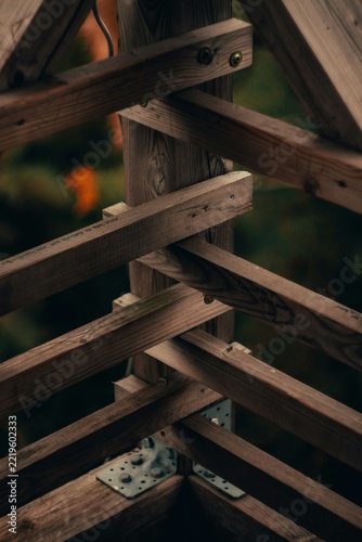 Close Up View of Architectural Wooden Beam Truss Structure and Joints on Blurred Nature Background