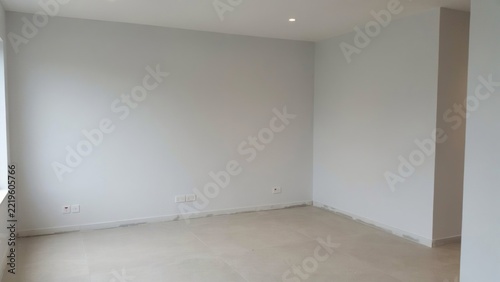 Empty bright room with white walls and light laminate flooring after renovation, ready for interior design