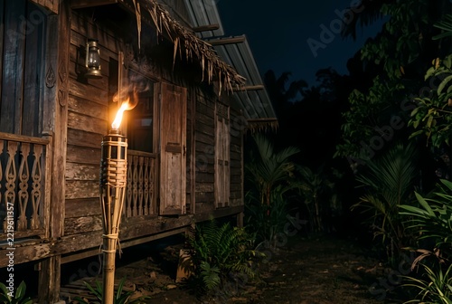 Vintage Bamboo Torch Illuminating a Traditional Malay House