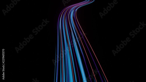 Glowing blue and pink light trails streaking forward along a curving path on black background