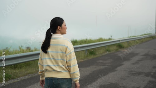 woman walking on a road on mountain in the morning
