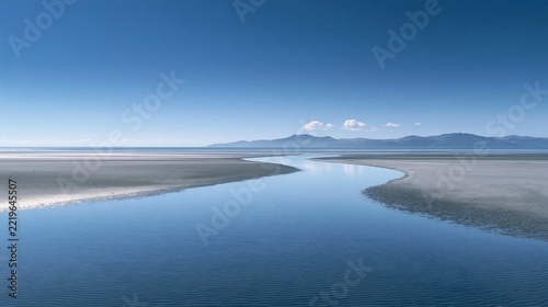 Serene blue river winding through flat landscape under clear open sky