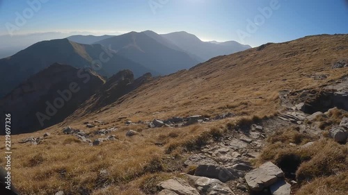 POV hiker walks with trekking poles across rugged terrain on the Czerwone Wierchy ridge
