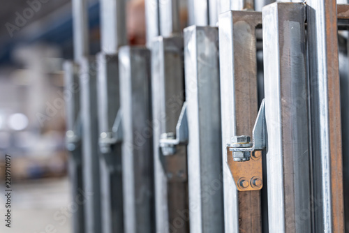 Hand holding a hinge fitting against a galvanised steel gate frame