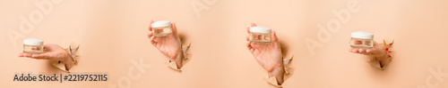 Hands holding cream jars bursting through paper background