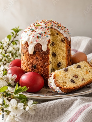 Glazed festive sweet bread with colorful eggs and delicate spring flowers