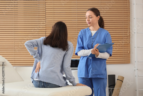 Back pain consultation, patient with lower back injury talking to a nurse or ...