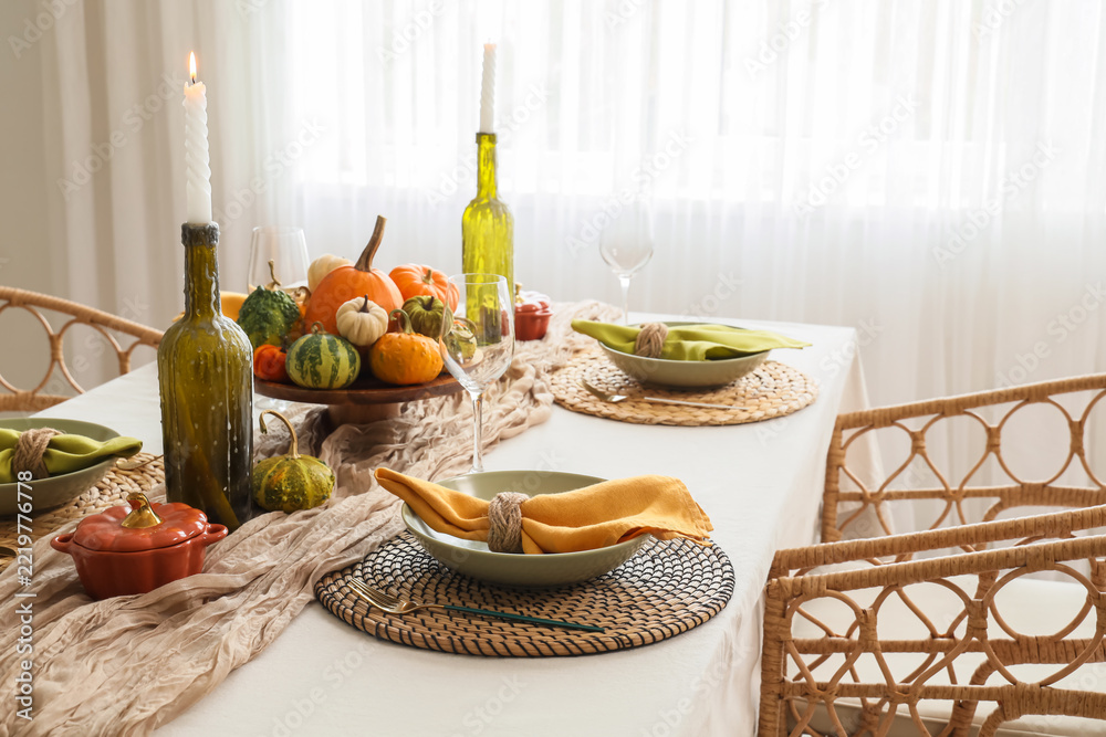 Fototapeta premium Thanksgiving dinner table setting, autumn harvest celebration and family gathering with pumpkins and candles in a cozy home dining room
