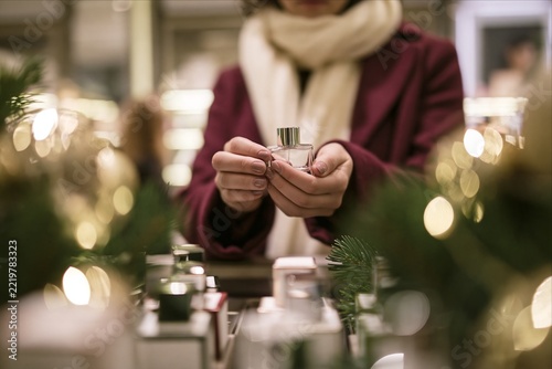 Woman Holding Perfume Bottle While Shopping for Christmas Gifts
