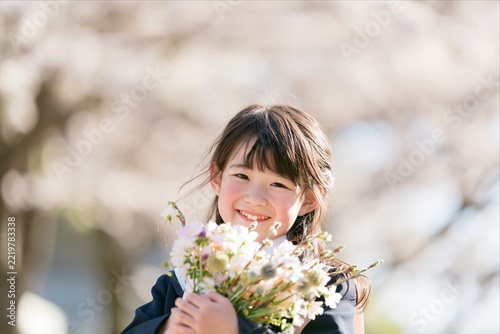 Smiling Asian Girl Holding Bouquet of Flowers in Spring Garden
