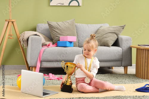 Achievement and success concept, little girl with gold trophy and medal parti...
