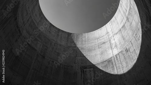 Modern architectural concrete interior with circular skylight and smooth surfaces