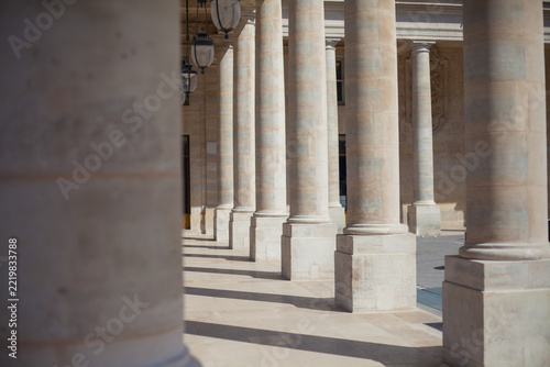 Fotografie Rows of stone columns with sunlight and shadows in classical Parisian colonnade