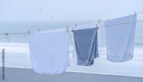Plain White and Muted Blue Linen Fabrics Moving Gently on an Anonymous Rooftop Clothesline, Minimal Mediterranean Everyday Life Scene
