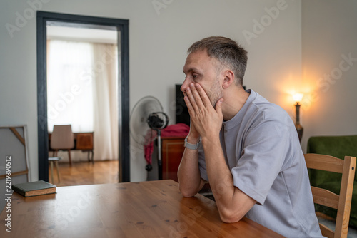 Man under stress from job insecurity, money anxiety, unemployment risk, career uncertainty, rising household expenses and economic pressure at home.