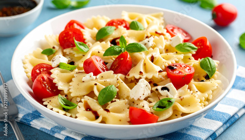 Caprese bowtie pasta salad with mozzarella cheese, tomatoes and basil with balsamic vinaigrette dressing. Ai