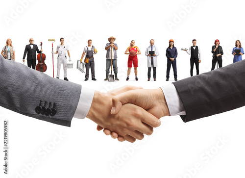 Business handshake with various workers from different professions standing in the background