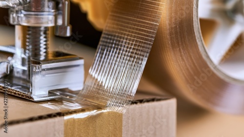 Tape machine glides over cardboard box