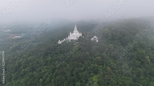Aerial view from drone of the white pagoda and temple in the mountain on cloudy day