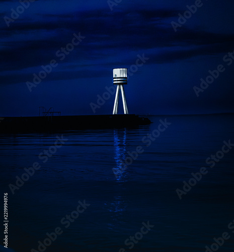 Illuminated Lighthouse Reflecting Blue Twilight