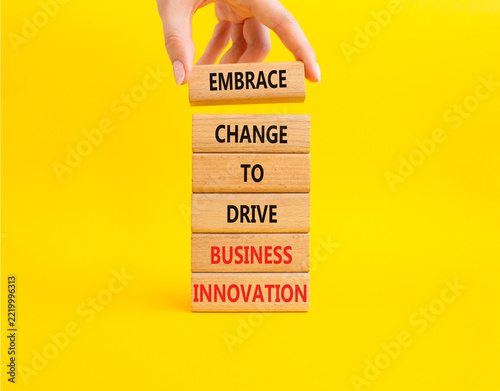 Concept words embrace change to drive business innovation on stacked wooden blocks. Hand placing top wooden block. Business transformation and innovation concept. Yellow background. Copy space.