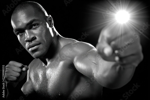 Boxer poses under studio lights, focused on the camera