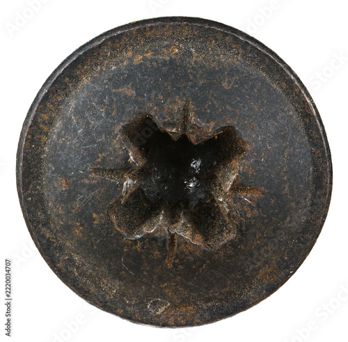 Dark, heavily rusted circular metal boss with a distinct four-point mounting slot