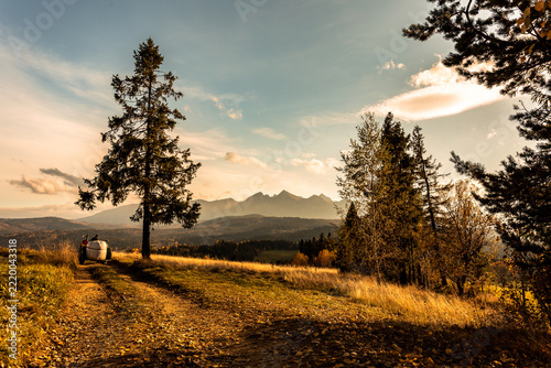 Majestic panoramic view of the Tatra Mountains landscape featuring snow-capped peaks, colorful forests, and picturesque valleys under a dramatic sky. Beautiful scenic nature and wilderness background