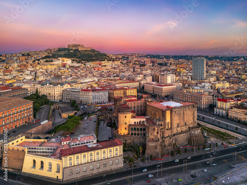 Sunrise over Naples castle Nuovo. NAPLES, ITALY - OCTOBER 3, 2026: Aerial cityscape view featuring Castel Nuovo and Castel Sant Elmo during a vibrant colorful sunrise.