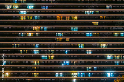 View of front view of hotel apartment building facade in Batumi - front view. Illuminated windows in georgian residential building with warm lighting at night. Architecture concept