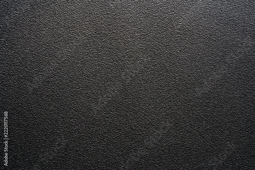 Black plastic texture full frame abstract rough dark background. Top view dark grey matte textured surface. Black grainy powder coated metal, industrial plastic or asphalt for modern design