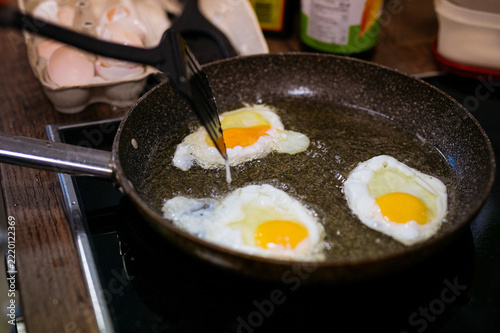 Frying eggs in a skillet to make Kai Dao for Thai street food