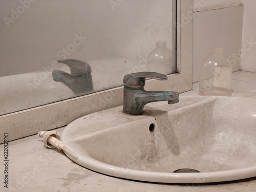 Old Bathroom Faucet with Water Stains Showing Plumbing and Maintenance Problem