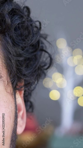 Vertical video: Showing man's left side moving with breath at home, LED tree lights, copy space