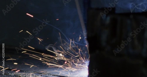 Industrial metal arc welding with intense bright sparks scattering close up