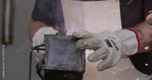Industrial arc welding on metal detail with ground clamp attached close up