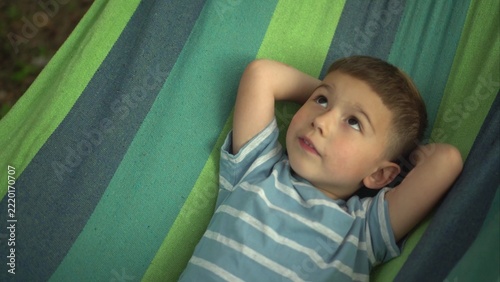Young Boy Relaxing in a Hammock While Swinging Outdoors, Close Up